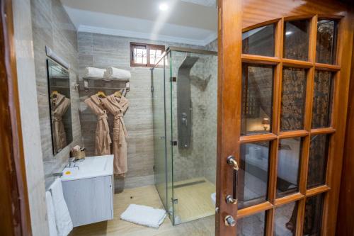 La salle de bains est pourvue d'une douche et d'une cabine de douche en verre. dans l'établissement Riad Sebti Fès, à Fès
