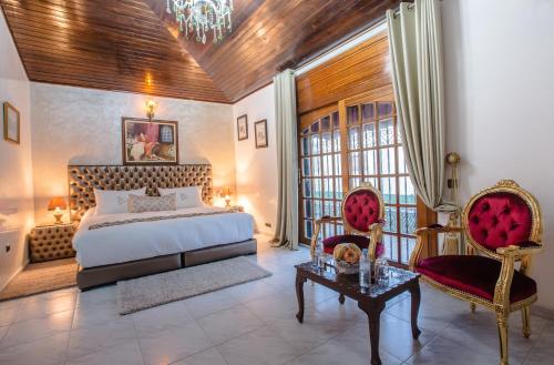 a bedroom with a bed and two chairs and a table at Riad Sebti Fès in Fès