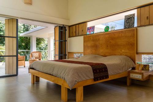 um quarto com uma cama grande e uma janela grande em StayVista at Davey's Townhouse with Breakfast & Pet Friendly Home em Mysore