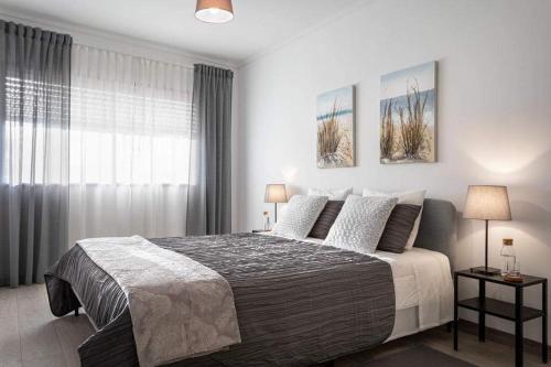 a bedroom with a large bed and a window at Home Sweet Home in Ílhavo