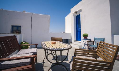 a patio with chairs and a table on a balcony at GIAMAKI APARTMENTS in Sifnos