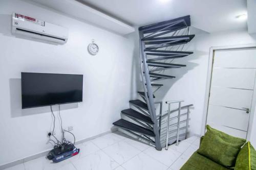 a spiral staircase in a living room with a tv at Lifestyle18 Hotel and Shortlet Apartments in Lagos