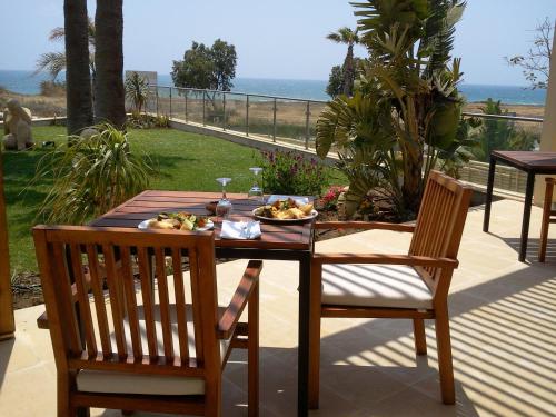 a table and chairs with a plate of food on it at E-Hotel Larnaca Resort & Spa in Larnaka