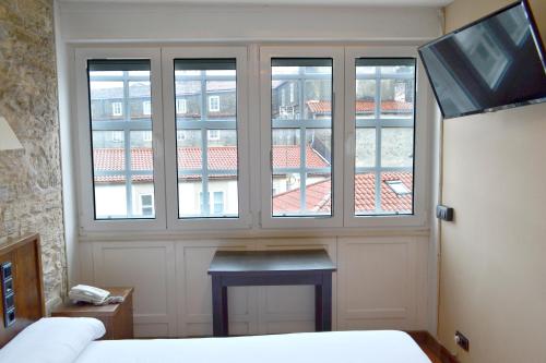 a bedroom with a window and a bed in it at Hotel Alda Avenida in Santiago de Compostela