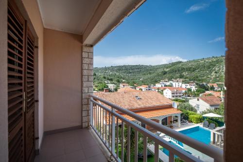 a balcony with a view of the city and the pool at Apartment Maja's Style in Vela Luka