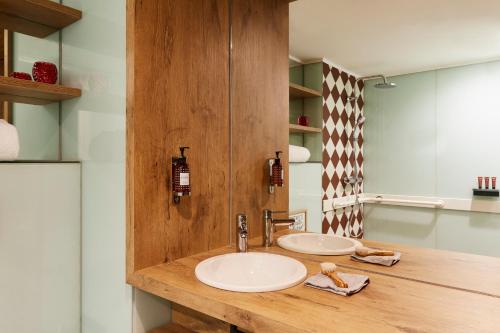 a bathroom with two sinks and a mirror at Hotel Indigo Antwerp City Centre by IHG in Antwerp