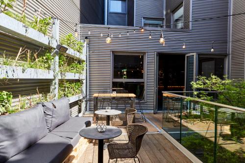 a patio with a couch and chairs and tables at Hotel Indigo Antwerp City Centre by IHG in Antwerp