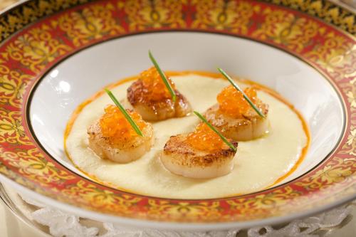 a plate of food with four pieces of food with chopsticks at Imperial Hotel & Restaurant in Vilnius