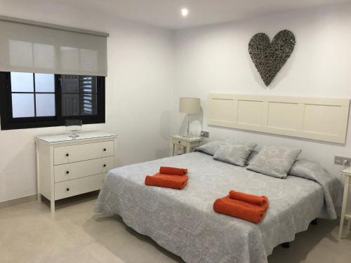卡門港的住宿－Casa MoJo，一间卧室配有一张带两个橙色枕头的床
