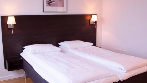1 dormitorio con 1 cama grande y 2 almohadas blancas en Hotel Montebello, en Oslo