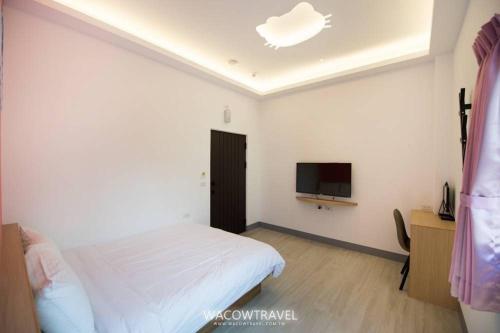 a bedroom with a bed and a flat screen tv at Xiaoliuqiu 88 Homestay in Xiaoliuqiu