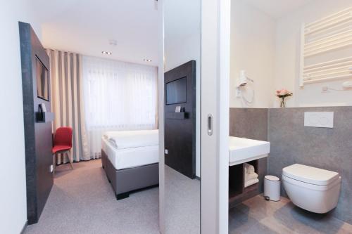 a bathroom with a toilet and a sink at City Hotel Würzburg in Würzburg
