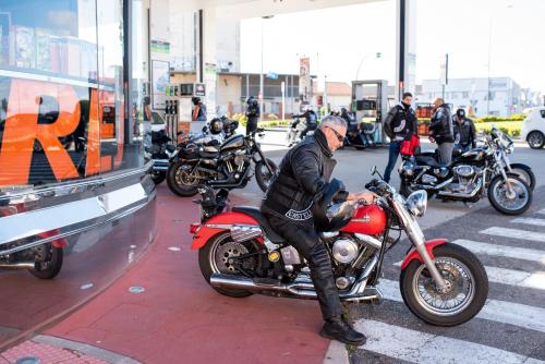 a man sitting on a red motorcycle on a street at Resotel in Villares de la Reina