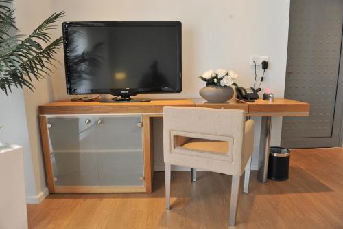 a wooden desk with a television on top of it at E-Hotel Larnaca Resort & Spa in Larnaka