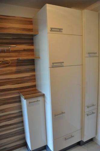 a closet with white cabinets and a refrigerator at Seeappartement Ingrid in Bodensdorf
