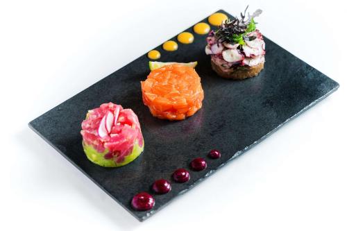 three different types of donuts on a black plate at Hyatt Centric Las Condes Santiago in Santiago