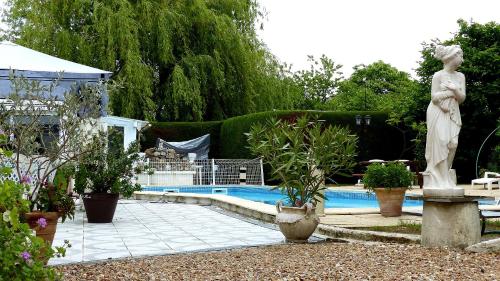 une statue d'une femme debout à côté d'une piscine dans l'établissement Les dauphins de Mareuil, à Mareuil-sur-Cher