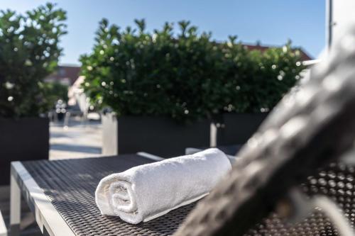 a white towel sitting on top of a wooden bench at Altstadthotel Guesthouse Die Galerie in Ingolstadt