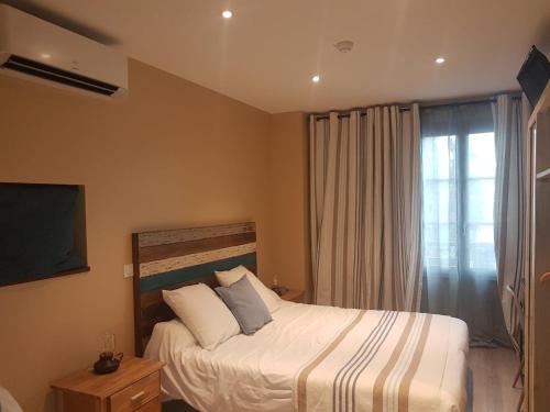 una camera da letto con un letto e una grande finestra di Logis Hôtel Terre de Loire a Belleville-sur-Loire
