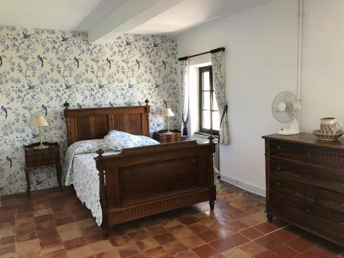 - une chambre avec un lit et du papier peint floral dans l'établissement Domaine de Favette, à Coursan