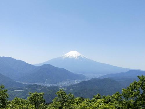 a snow covered mountain in the middle of a valley at ログハウスkizuki in Tsuru 