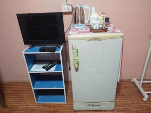 a small refrigerator with a tv on top of it at ห้องพัก โฮมทรัพย์ in Ban Thung Pla Kat