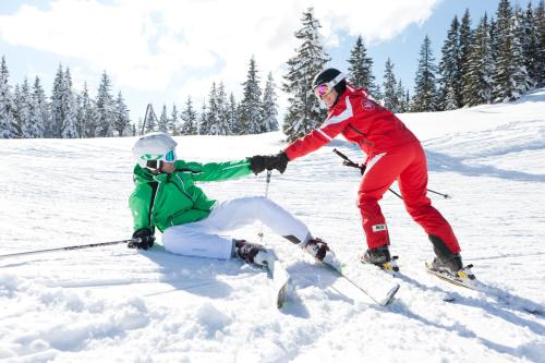 two people on skis in the snow at Pension Zum wilden Hannes in Wagrain
