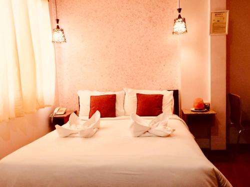 um quarto com uma cama branca com duas toalhas em TINHAT Halal حلال Certified Boutique Hotel And Restaurant em Dávao