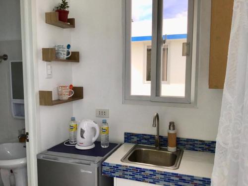 a small kitchen with a sink and a window at 1888 Beach Resort in Dumaguete