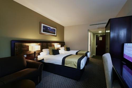 a hotel room with a bed and a flat screen tv at Millennium & Copthorne Hotels at Chelsea Football Club in London
