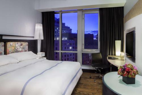 a hotel room with a bed and a desk with a window at Hyatt Union Square New York in New York