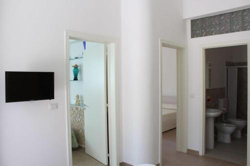 a bathroom with a toilet and a tv on a wall at Villa Simonetta in Alliste