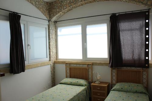 a bedroom with two beds and two windows at Villa Simonetta in Alliste