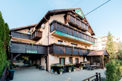 a large building with a patio in front of it at Három a Kislány Panzió in Hévíz