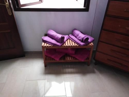 プエルト・デ・ラ・クルスにあるCarlos y Rosaの紫のタオルがテーブルに掛けられた部屋