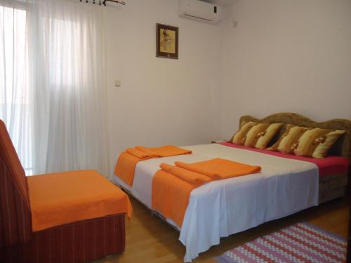 a bedroom with two beds with orange sheets at Apartments Villa Mićunović in Herceg-Novi