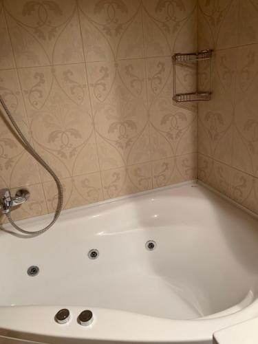 a white bath tub in a bathroom with a shower at Apartament Reset Club in Brăila
