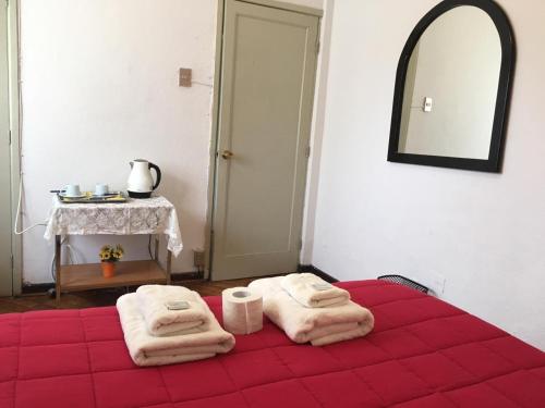 una camera da letto con un letto rosso e asciugamani di Viña Colores a Viña del Mar