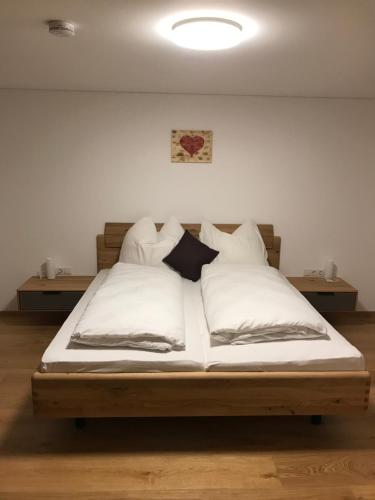 a bedroom with a bed with white sheets and pillows at Murmenta Appartements in Vandans