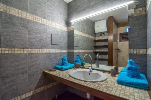 a bathroom with a sink with blue towels on it at Studio Marigot, Vue Panoramique in Saint Martin
