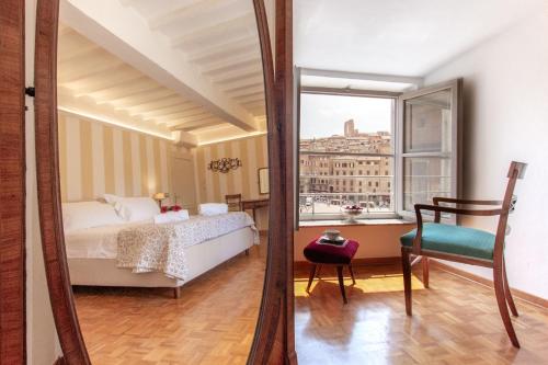 a bedroom with a bed and a mirror at Palazzo Chigi Zondadari in Siena