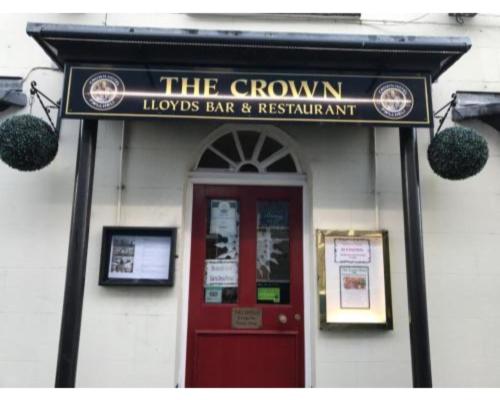 a building with a sign that reads the crown lionsart and restaurant at Crown Hotel in Pwllheli