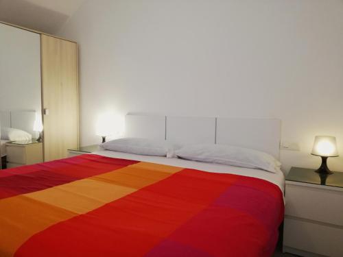 Una cama con una manta de color arco iris. en Verdemar Apartment with Sea View and Garden, en Nerja