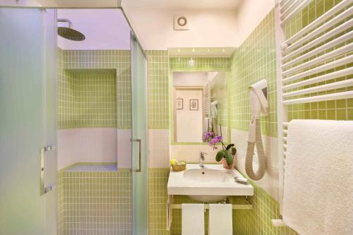 y baño con lavabo y ducha. en Hotel Girasole en Sorrento