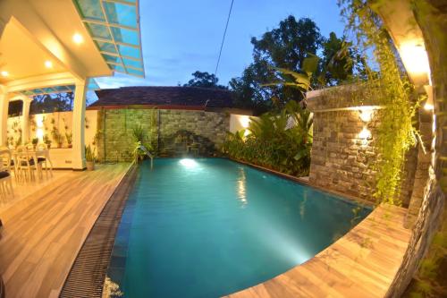 a swimming pool in the backyard of a house at Negombo New Queen's Palace in Negombo