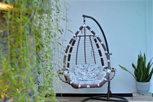 a swing chair in a room with a plant at Negombo New Queen's Palace in Negombo
