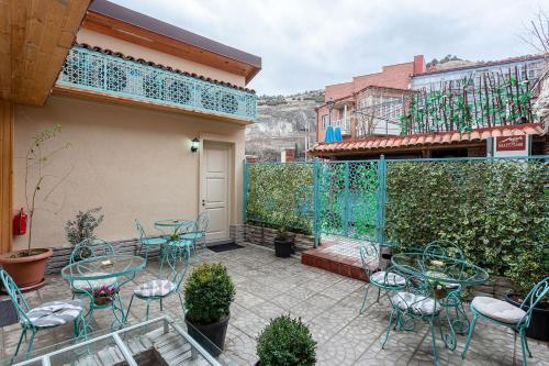 Un patio con mesas y sillas y una valla. en Botanical 21, en Tiflis