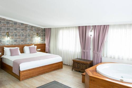 a bedroom with a large bed and a large window at Infinity City Hotel in Fethiye