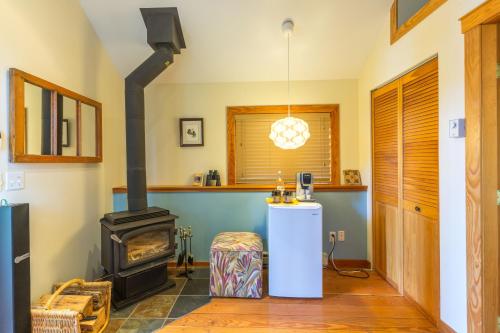 a living room with a wood stove in it at Tranquility Bay Waterfront Inn in Sechelt