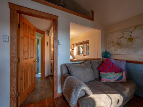 a living room with a couch and a door at Tranquility Bay Waterfront Inn in Sechelt